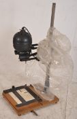 A vintage German photgraphic enlarger by Leitz raised over a wooden base