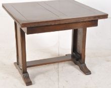 A 1930's oak Art Deco draw leaf refectory dining table. Shaped supports united by stretcher