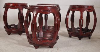 A set of 4 Chinese hardwood barrel stools .Raised on  pierced shaped supports with circular tops
