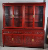 A Chinese hardwood sideboard / display cabinet. Having four short drawers above four carved panel