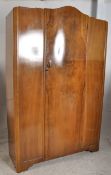 A 1930's Art Deco walnut double wardrobe. The shaped door to centre having open storage within