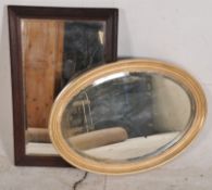 A vintage oak framed mirror together with an oval gilt framed mirror, both with bevelled edges