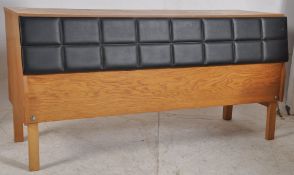 A 1970's retro Danish oak and leather/vinyl sideboard. Raised on tapered legs having an angular wide