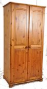 A contemporary pine single wardrobe having bun feet with upright doors. Together with a green