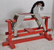 A vintage 1950's painted rocking horse, the red painted base with grey horse. 74cm x 105cm x 37cm
