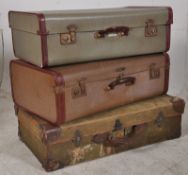 A vintage stack of suitcases to include a green canvase de-mob case and 2 vintage 1950's cases