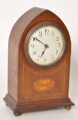 An Edwardian mahogany inlaid spire shaped mantle clock. The enamle face set within glass having