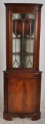 A Georgian flame mahogany bow front corner cabinet. The astragal glazed cabinet over cupboard