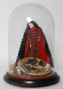 A 19th century porcelain doll, in pedlar girl form, with miniature dioramic scenery to base. Wearing