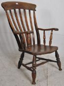 A Victorian beech and elm windsor chair. Raised on turned legs united by stretchers. Saddle seat
