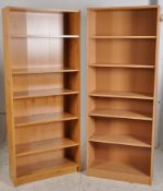 A near pair of tall bookcases having adjustable shelves