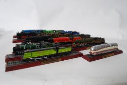 A collection of model traines being mounted on wooden plinths and track with brass effect name