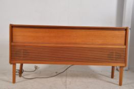 A 1960's teak Danish style HMV radiogram raised on tapered feet with slatted front having record