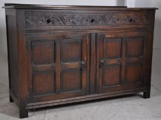 A 1940's Jacobean revival oak sideboard having carved doors and drawers. Three short drawers over
