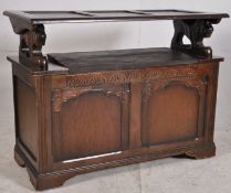 A 1930's oak monks bench / hall settle havign carved sides, lift up back. later hinged seat to
