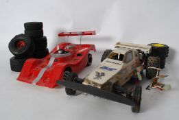 A vintage remote control car - dune buggy style together with a vintage le mans remote control