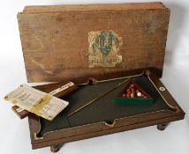 A good early 20th century Nuku table top parlour billiards game. Featuring a miniature sprung cue,