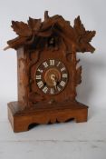 A vintage carved wood West German cuckoo clock, with movement in rear and a spare movement