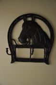 A cast metal coat / hat rack in the form of a horse, with folding hooks to the  front.