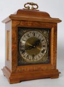 An 18th century style wooden mantel clock with brass 7 jewel movement.