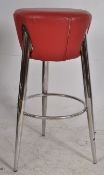 A good quality red leather upholstered atomic style chrome bar stool having peripheral foot
