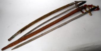 Two decorative swords in scabbards with brass decoration to hilts