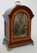 A mahogany arched top triple fusee boardroom bracket clock. The silvered dial playing 2 tunes on 8