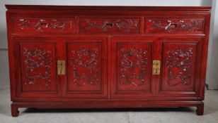 A Chinese hardwood sideboard / dresser base. Havingh four short drawers above four carved panel