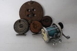 A Garcia 642 fishing rod reel, along with four others - three being turned wood, the other an