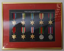A collection of replacement medals in a frame on a green baize background