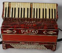 A 20th century  Pieto Accordian in faux red marble finish complete with strap.