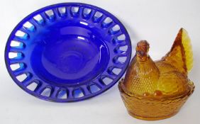 A large vintage studio pierced blue glass fruit bowl 41cms along with a amber pressed glass