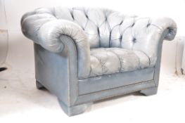 A grey leather chesterfield antique style armchair. Raised on leather bracket feet with deep button