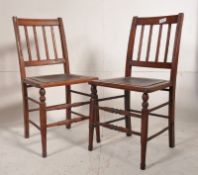 A pair of Edwardian pine bedroom chairs having turned legs with upholstered seats and spindle