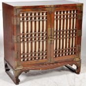 A Chinese mid 20th century hardwood altar cabinet. Raised over shaped supports with curtain doors