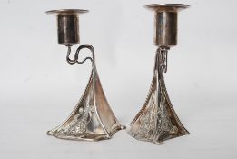 A pair of contemporary sterling silver hallmarked candlestick holders in the Archie Knox style.