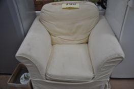A large upholstered armchair with cream washable cover.