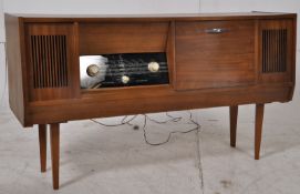 A 1970`s teak wood radiogram sideboard. Raised on tapered sides with a breakfront body having radio