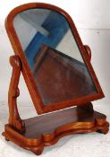 A Victorian mahogany swing mirror on carved supports, leading to a plinth base.
