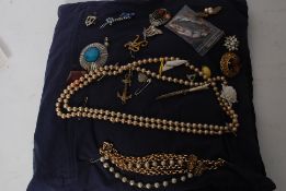 A selection of costume jewellery on display pad to include broaches, necklaces, pendants etc