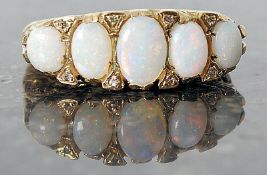 A ladies 9ct 5 opal and diamond ring with raised c scroll chased edged mount.