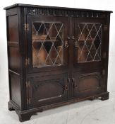 An Ercol style oak Jacobean revival bookcase / display cabinet. The peg jointed elm top over leaded