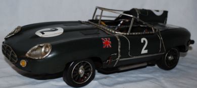 A vintage style tinplate toy model of a jaguar racing car, with moving wheels  and detailed