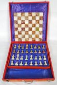 A cased onyx chess set along with a matching chess board.
