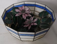 A large Tiffany style stained glass lampshade having been converted to a fish bowl complete with