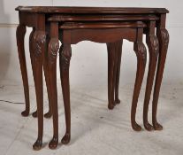 A walnut and mahogany regency style graduating nest of tables, all with glass insets of the walnut