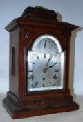 A late 19th century / early 20th century oak cased bracket clock. The silvered dial with subsiduary