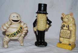 Three vintage style cast metal advertising moneyboxes, one in the form of Michelin Bibendum, Peanut