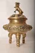 A large 19th century Chinese / oriental brass tripod censor urn, with temple lion figures to top