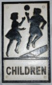 A vintage style 20th century cast metal road warning sign for `Children` depicting children play to